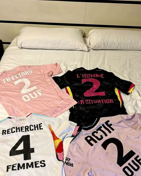 Quatre maillots floqués posés sur un lit